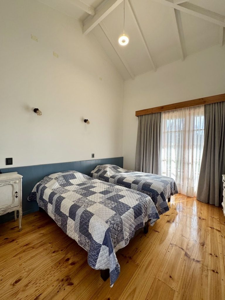 Guest bedroom with timber floor and high ceiling